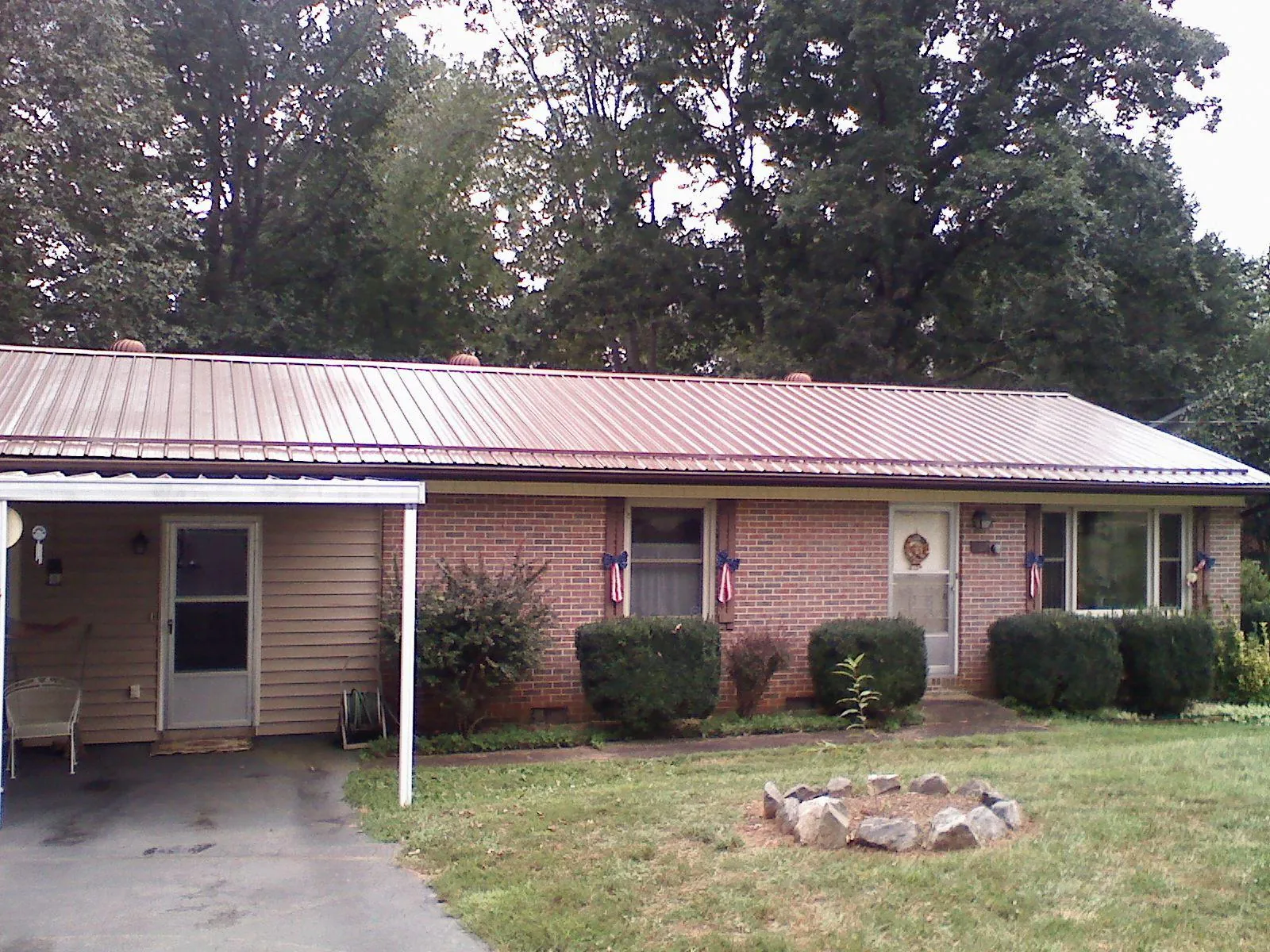 Bronze metal roof and carport on a brick ranch home — Roof Repair work by our crew in Calumet City